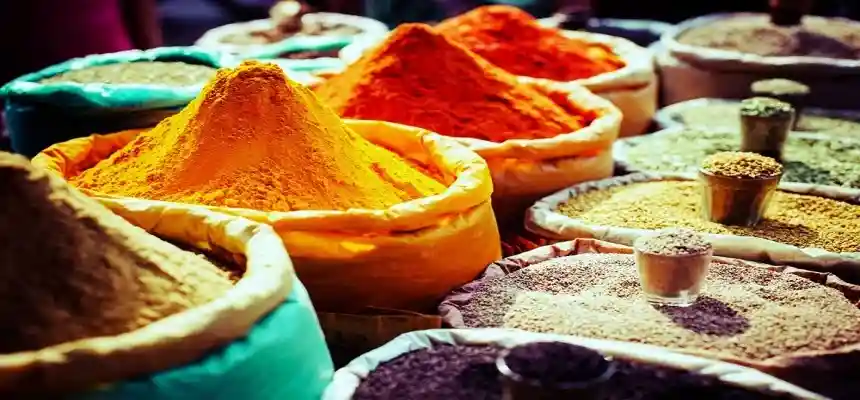 Mercado de especias Khari Baoli Delhi — sacos coloridos de especias rojas naranjas y verdes expuestos Vieja Delhi tour gastronómico India